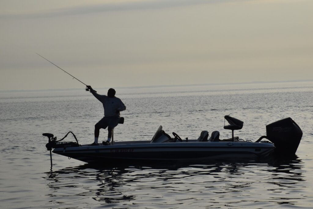 angler fishing at sunrise in a boat